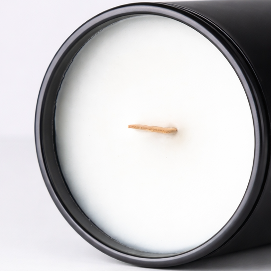 Black candle with a white center on a light gray background