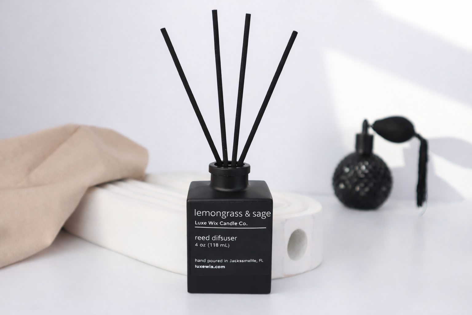 Diffuser with lemongrass and sage fragrance on a white surface